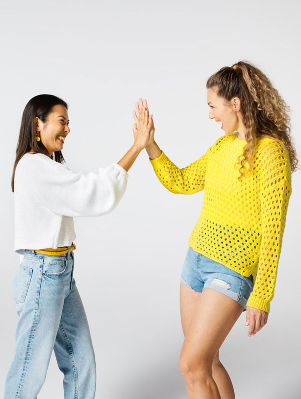 Two women high fiving each other and smiling.