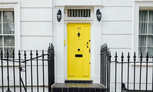 A white house with a yellow door. 