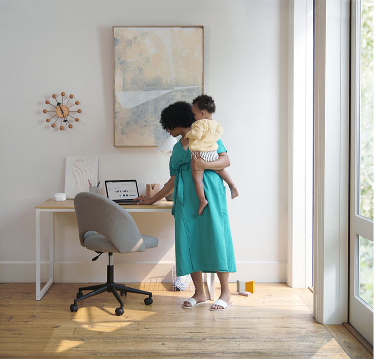 mother holding a todler managing her home network via the eero secure features
