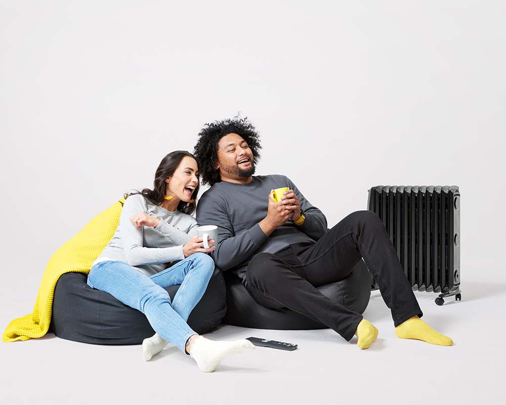 happy couple staying warm watching tv